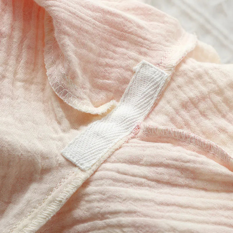 Women's pink pure cotton gauze long sleeve lounge suit top and trousers on a hanger.