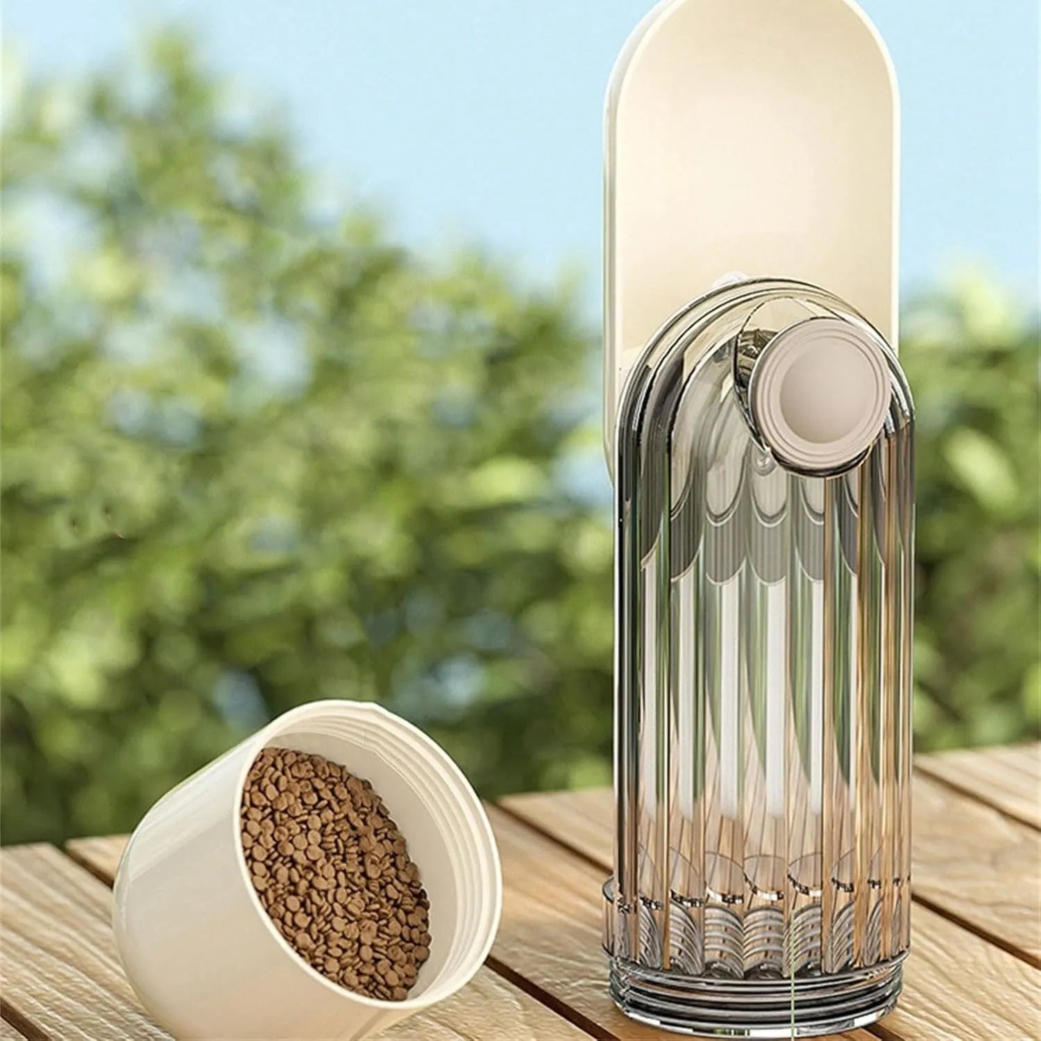 Beige foldable dog water bottle with food container, showing dispenser tray and compact size.