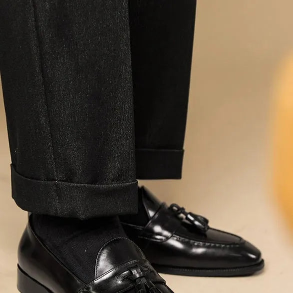 Men's black and brown tassel loafers with polished leather upper and rubber sole in British business casual style