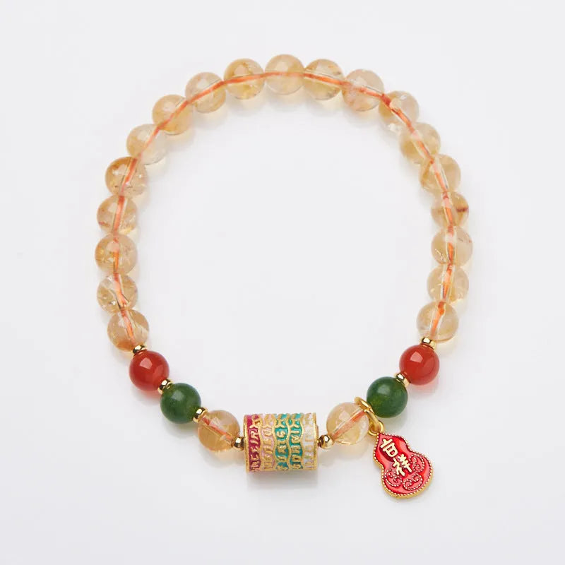 Close-up of a hand-woven citrine five sutra bracelet with 6mm geometric beads on a wrist.
