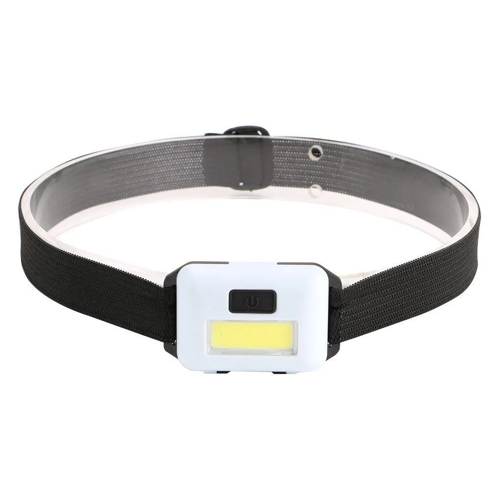 Compact black LED headlamp with a fabric head strap, shown in use.