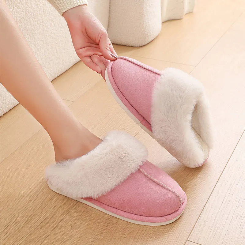 Women's brown plush indoor slippers with round toe, flat heel, and decorative stitching.