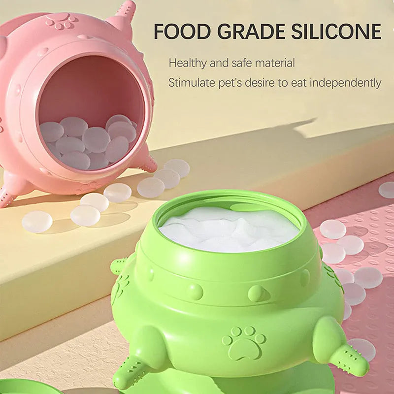 Pink silicone pet milk feeder with four nursing pacifiers and a lid on a flat base.