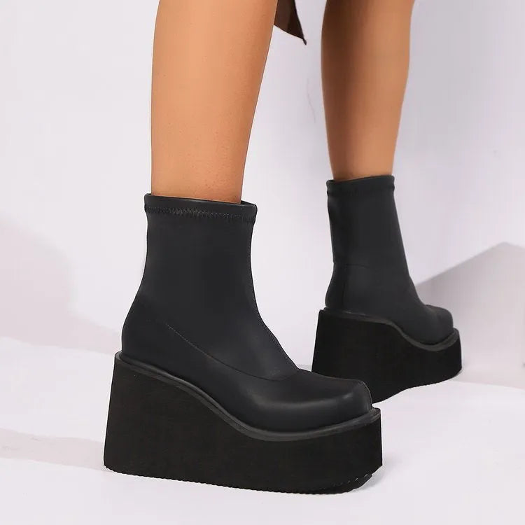 Black plus size women's ankle boots with a wedge heel and round toe on a waterproof platform sole.