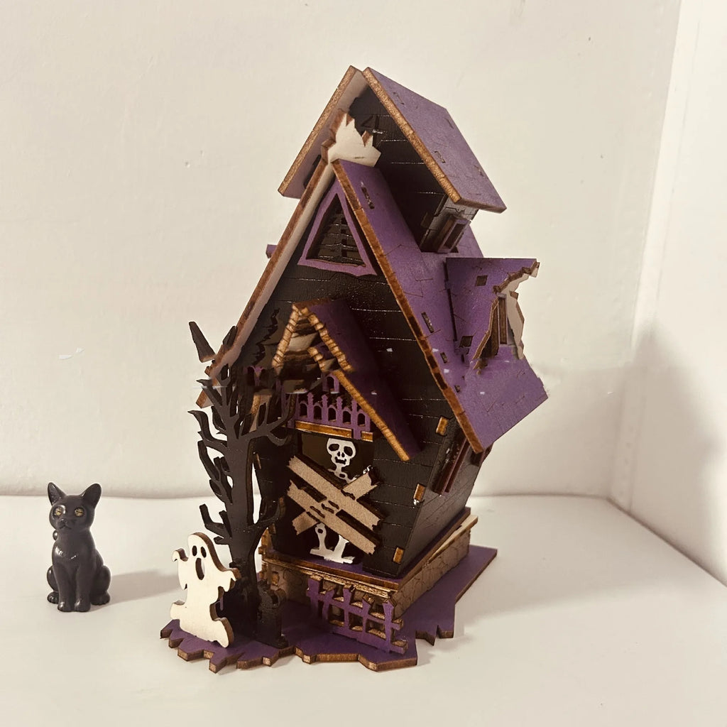 Wooden DIY Halloween haunted house table decoration with glow-in-the-dark details, shown unpainted.