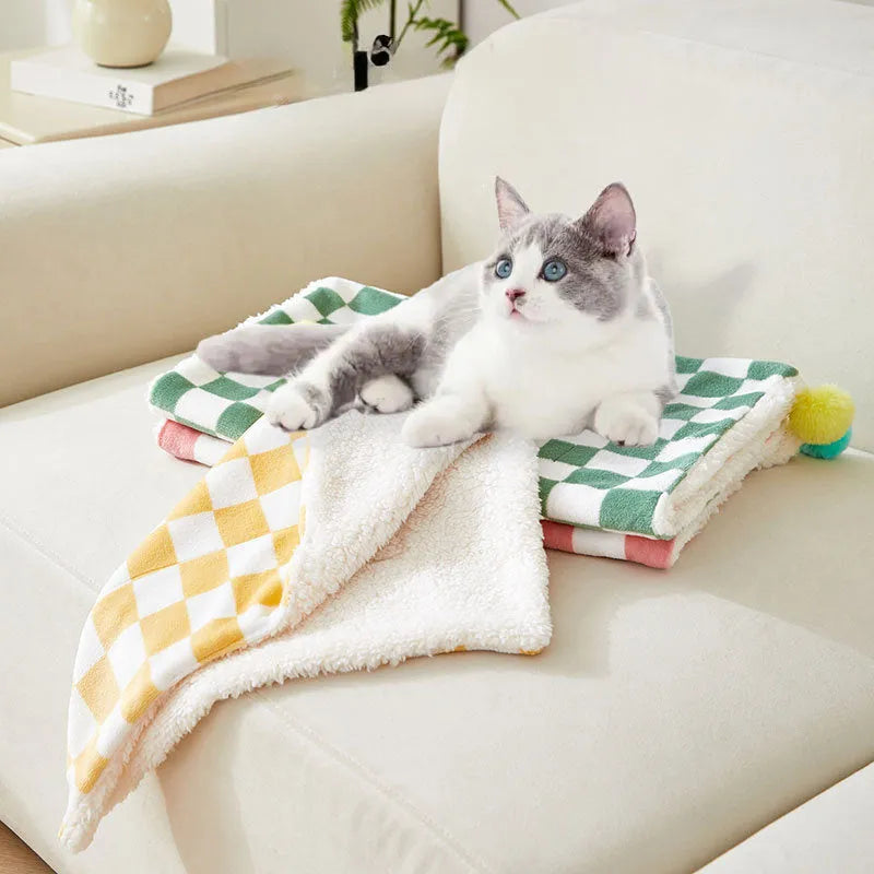 Green plaid pattern pet blanket with soft fleece texture on sofa