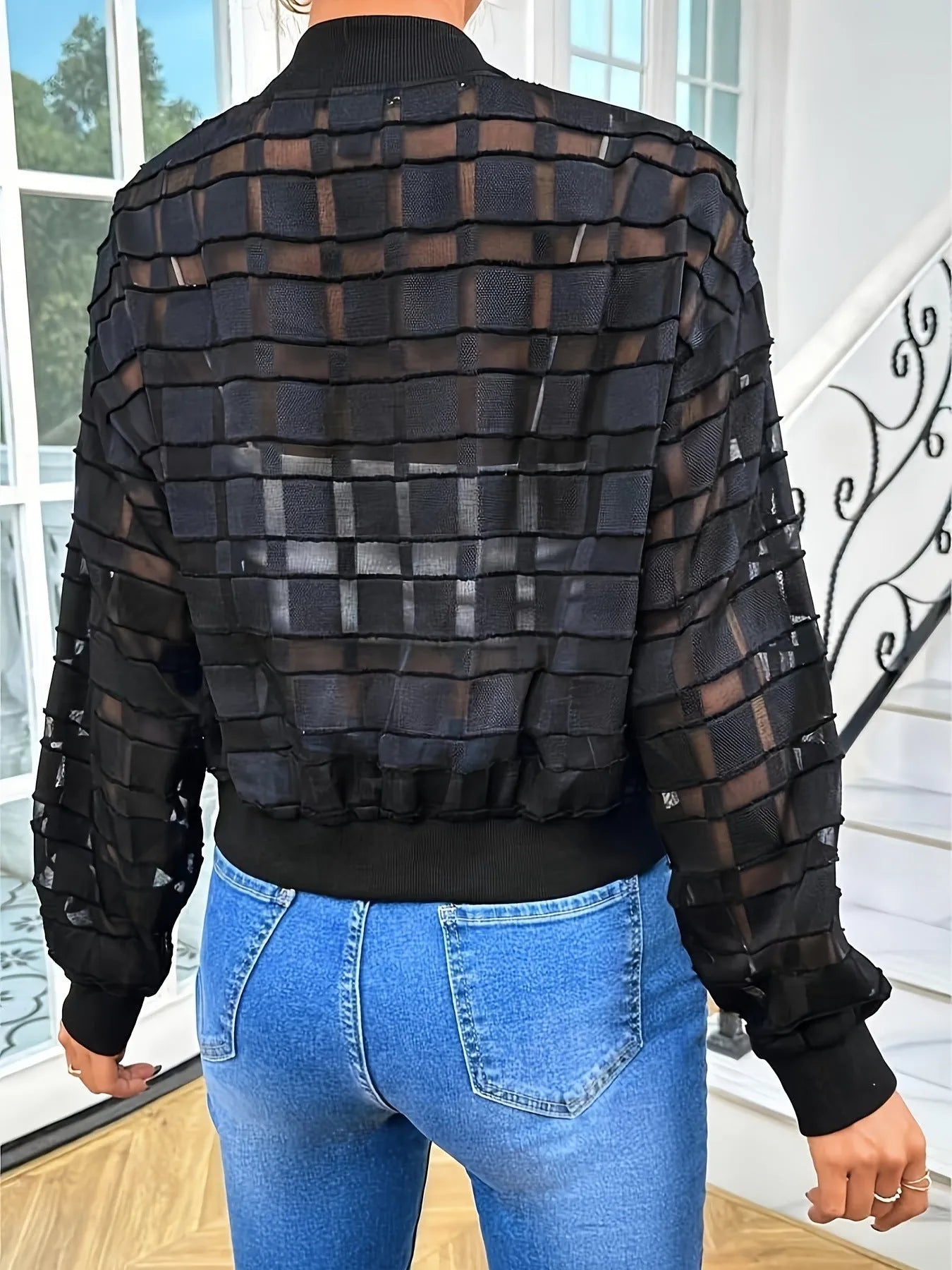 Black women's casual jacket with geometric pattern, semi-transparent fabric, front zipper, and long sleeves.