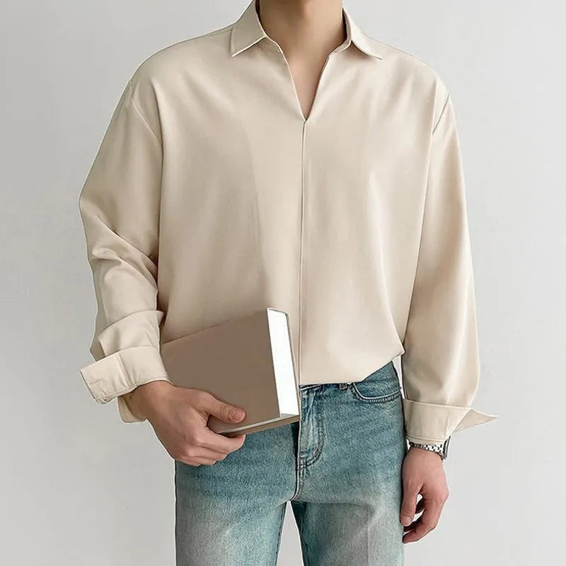 Man wearing a loose fit light business casual shirt in blue, showing lapels and long sleeves.