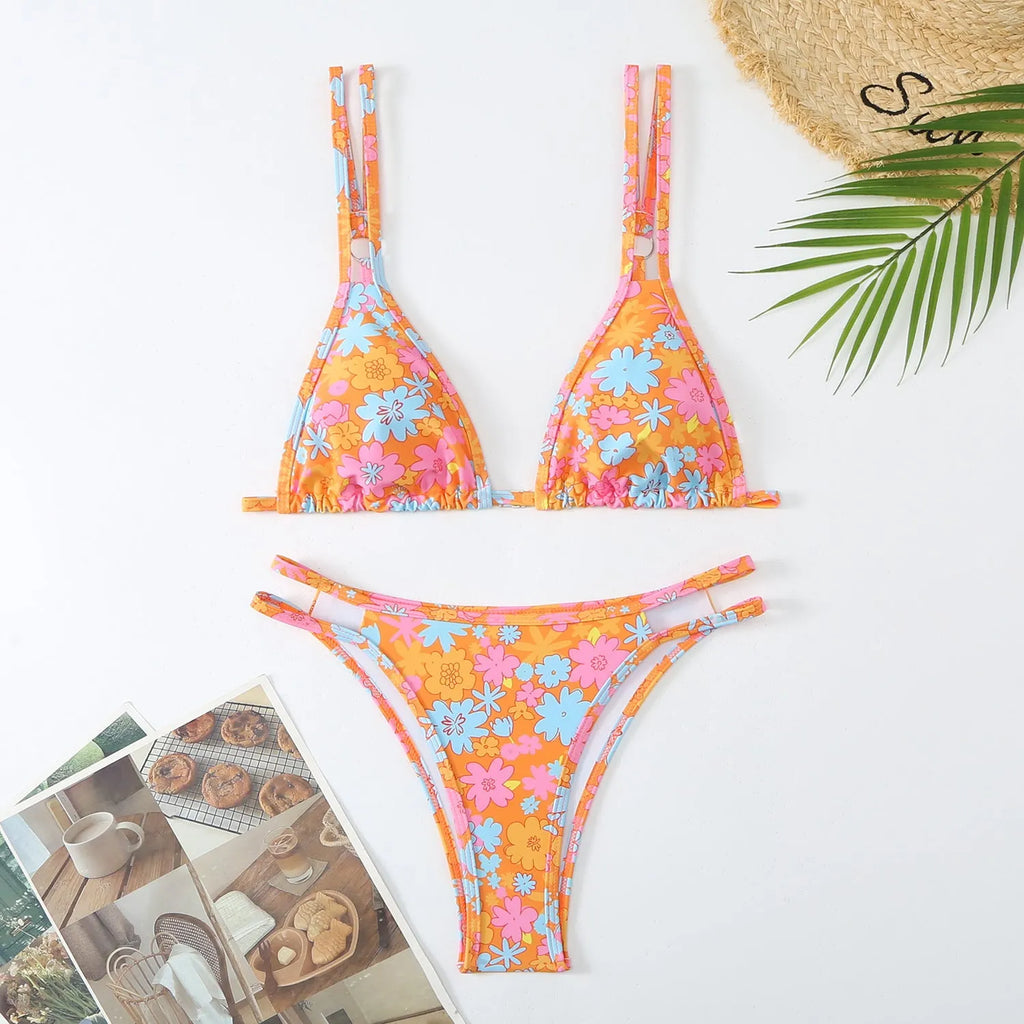 Women's printed halterneck bikini set in blue with floral pattern, showing top and briefs.