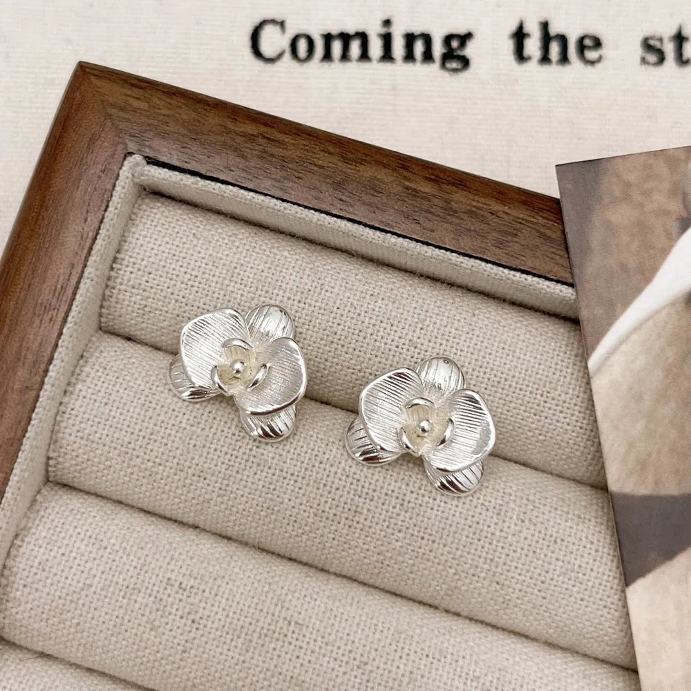 Retro floral fashion earrings in gold or silver colour with petal detailing on copper base.
