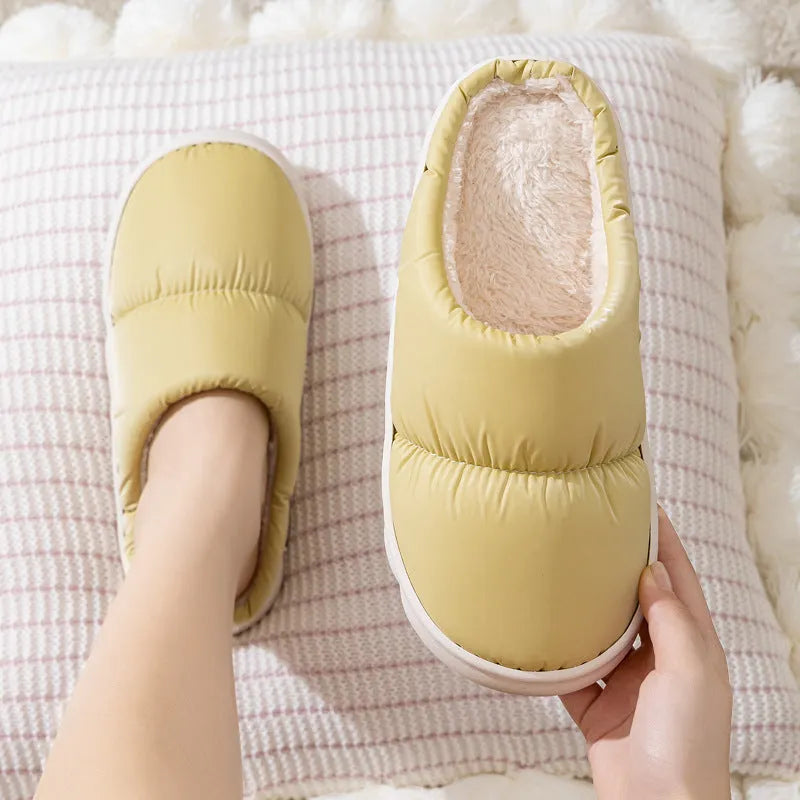 Pair of down cotton indoor slippers with artificial leather upper and thick rubber sole.