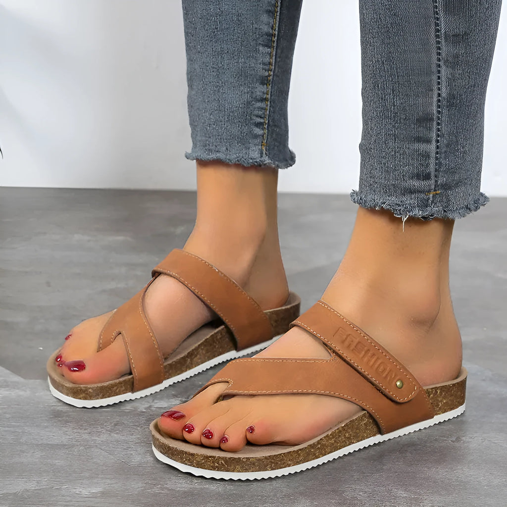 A pair of flat toe ring thick-soled flip-flops in a solid colour on a plain background.