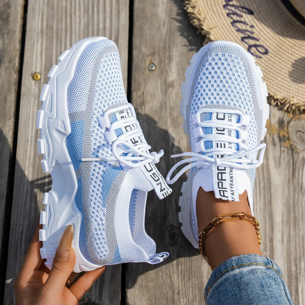 Women's Flyknit mesh sneakers in grey and white colour with flat rubber sole and lace-up front.