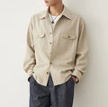 Men's light sand rice coloured cotton blend lapel shirt laid flat, showing long sleeves and simple collar design.