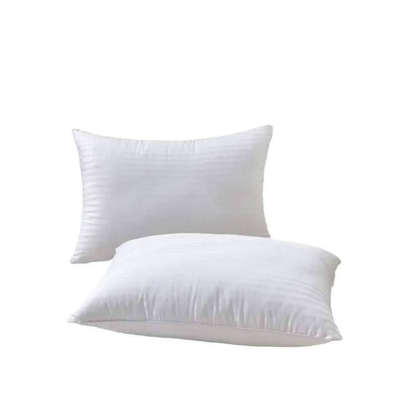 White cotton satin stripe pillow with feather and cotton filling on a bed.