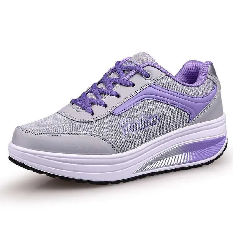 A pair of women's grey powder travel sports shoes with a mid-height heel on a white background.