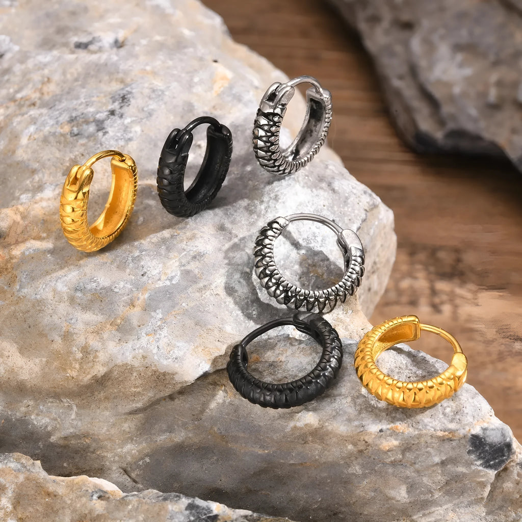 A pair of stainless steel earrings with a raised snake pattern texture in a black or gold finish.