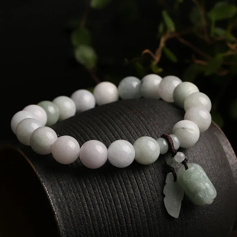 Emerald green jade bracelet with hanging symbolic charms including Maitreya Buddha design