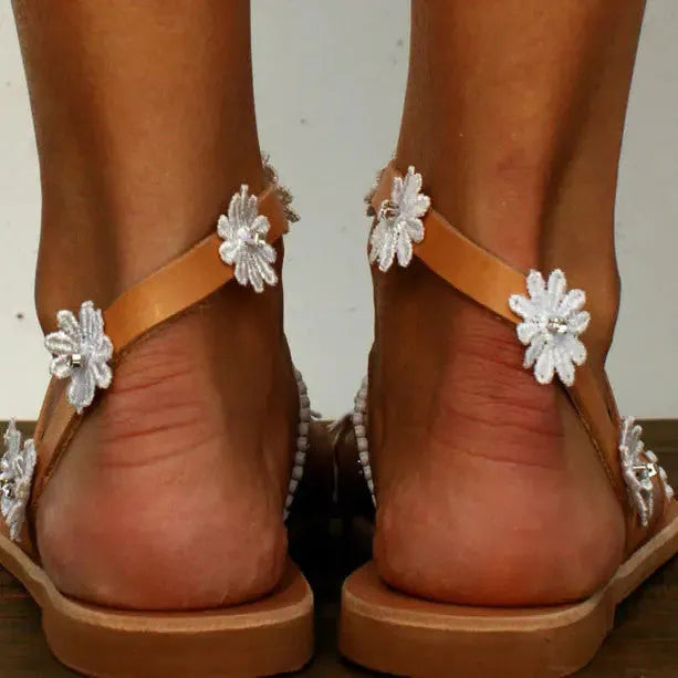 Brown ladies flat sole Roman sandals with floral pattern and elastic sleeves