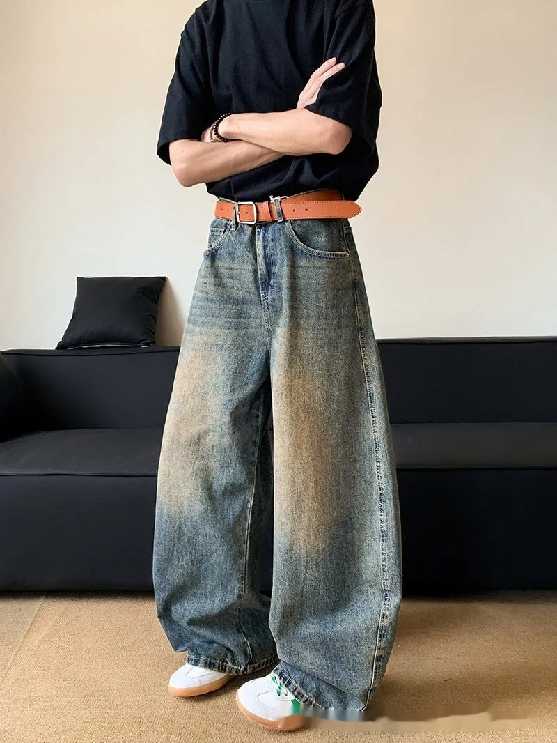 Man wearing retro blue distressed wide-leg denim jeans with a mid waist and zipper fly.