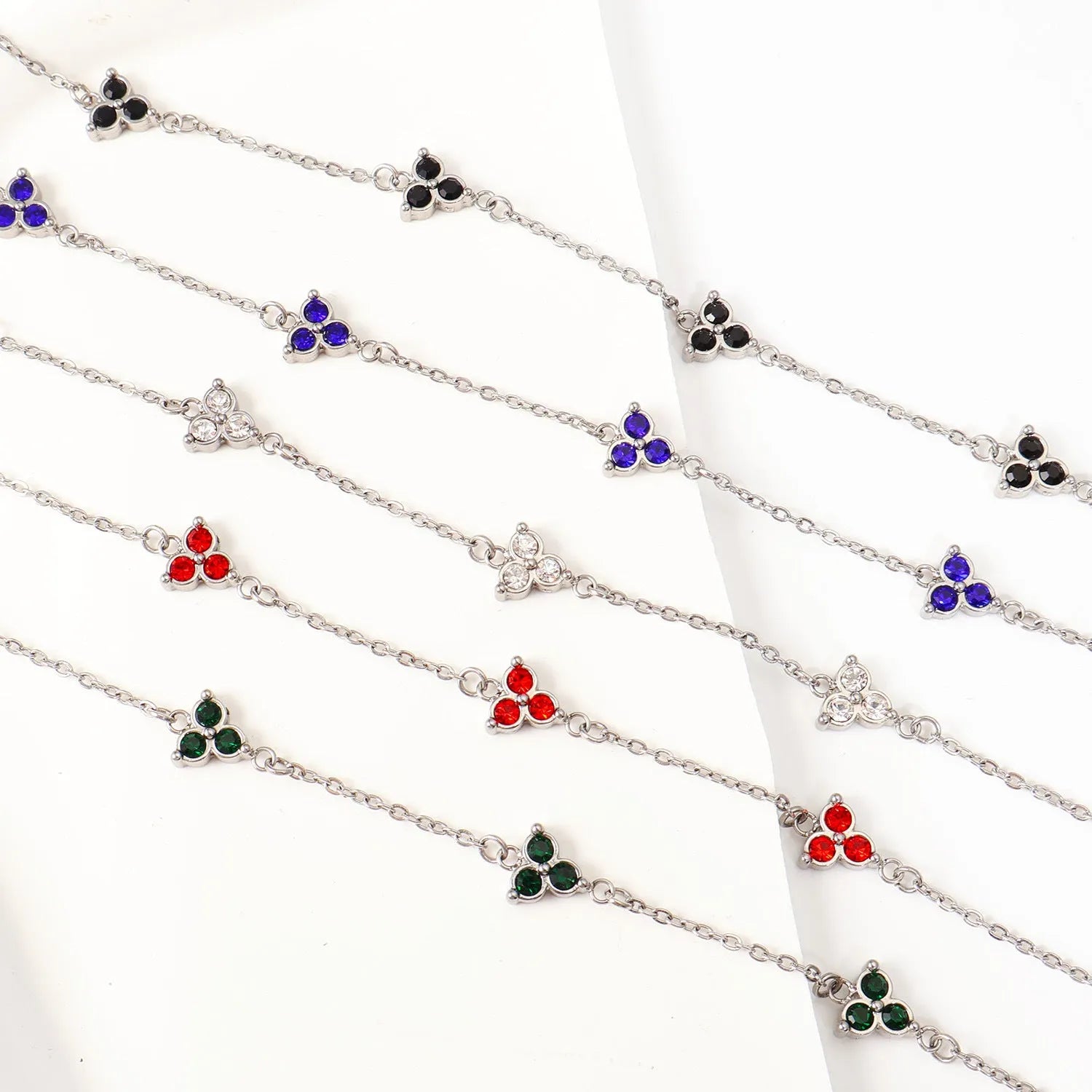 Women's stainless steel bracelet with a geometric triangle pendant, shown in gold and steel tone options with coloured stones.
