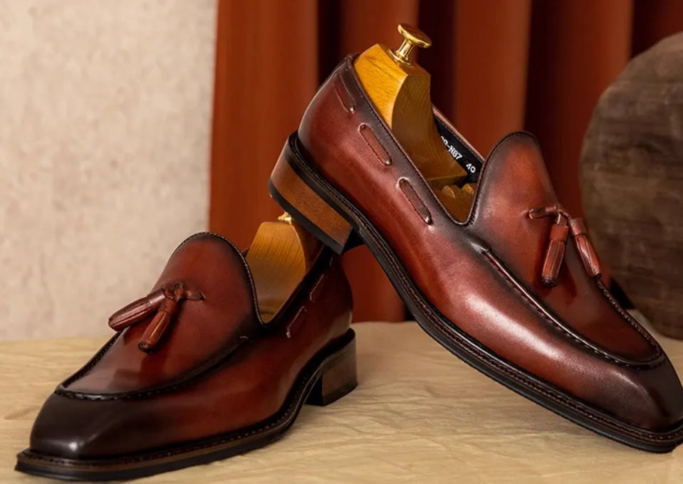 Men's black and brown genuine leather slip-on loafers with a pigskin lining, shown in multiple sizes.