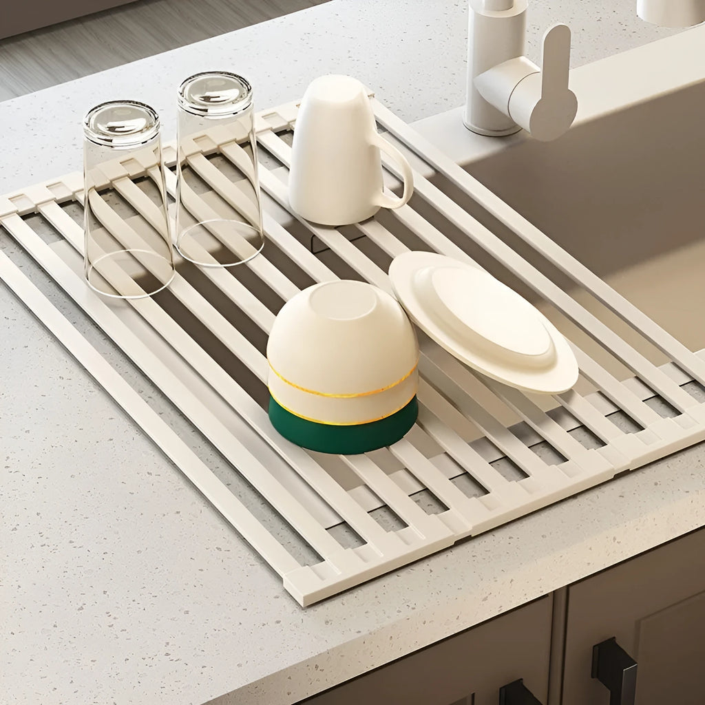 Milky white foldable stainless steel kitchen draining rack shown next to a sink.