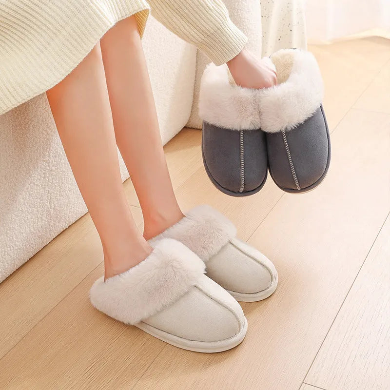 Women's brown plush indoor slippers with round toe, flat heel, and decorative stitching.