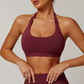 Women's halter-style sports bra in multiple colours, showing hollow back design and removable pads.