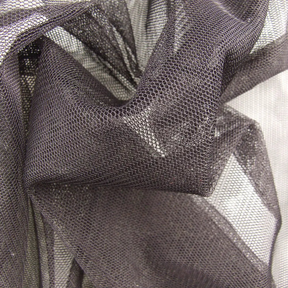 Adult wearing a full mesh anti-mosquito suit with hood, trousers, and booties for outdoor camping.