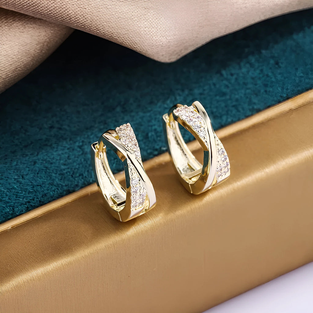 A pair of geometric drop earrings in 14K yellow, made from copper with zircon accents.