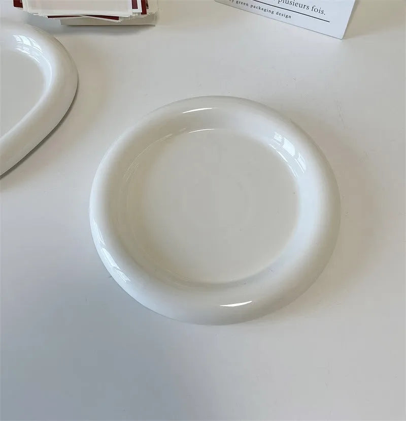 White porcelain round plate with chubby toot bear doodle pattern, shown as a plant saucer.