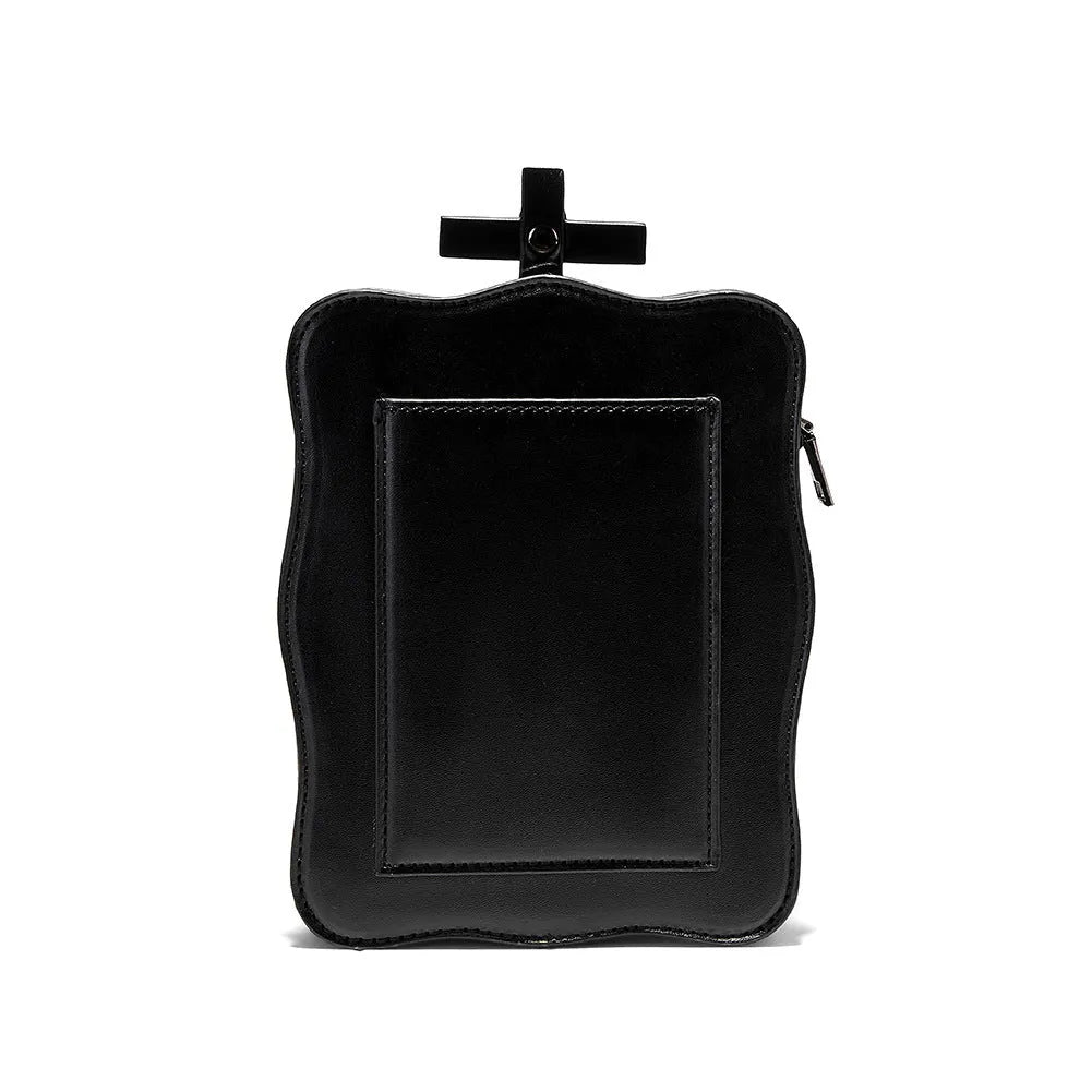 Black mini square crossbody bag with skull embossing, chain detail, and metal rivets on a vertical PU leather messenger bag.