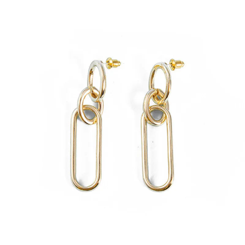 Geometric sterling silver needle hoop earrings with ring and line design on a white background.