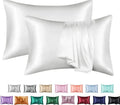 Dark blue polyester satin pillowcase with envelope closure on a bed with white sheets