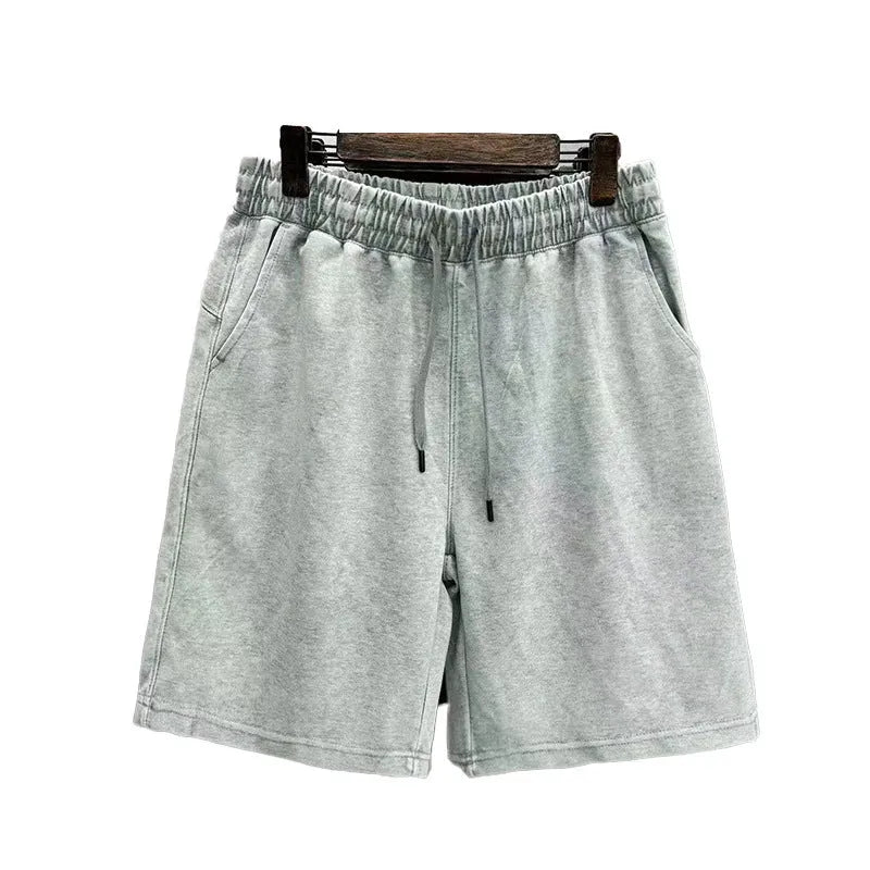 Men's charcoal black distressed denim shorts with straight leg and fifth pants length on a white background.