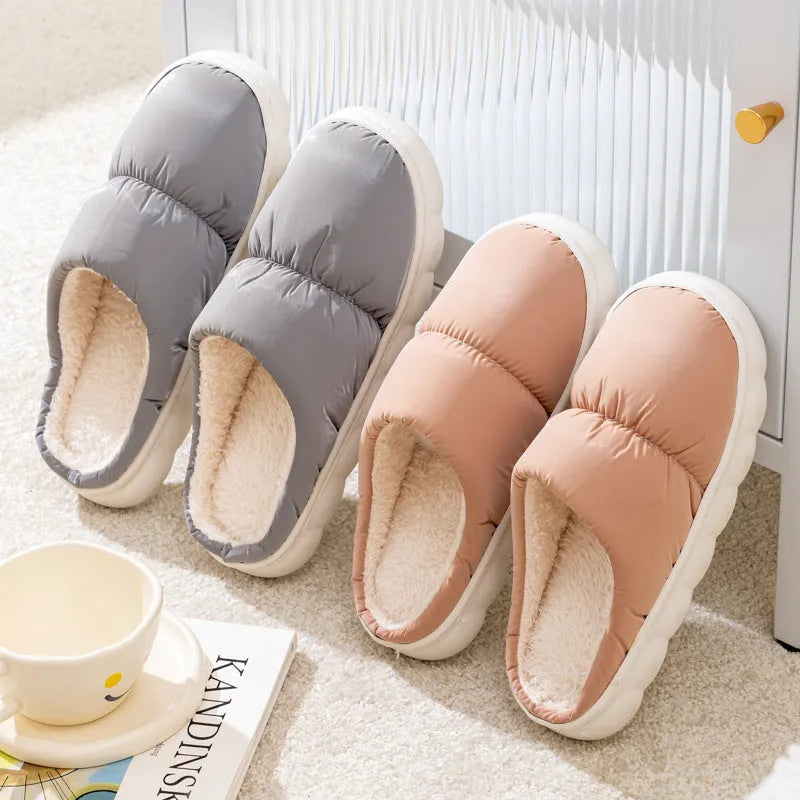 Pair of down cotton indoor slippers with artificial leather upper and thick rubber sole.