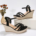 Women's wedge sandal with fish mouth toe design in black cloth upper.