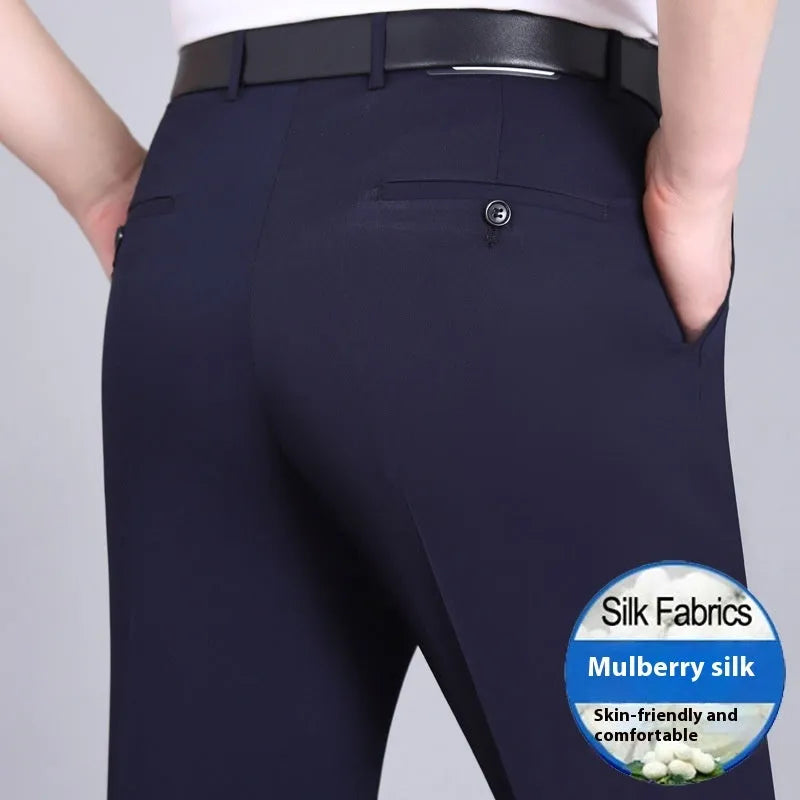 Man wearing dark blue straight-leg suit trousers with a high waist, made from a mulberry silk blend fabric.