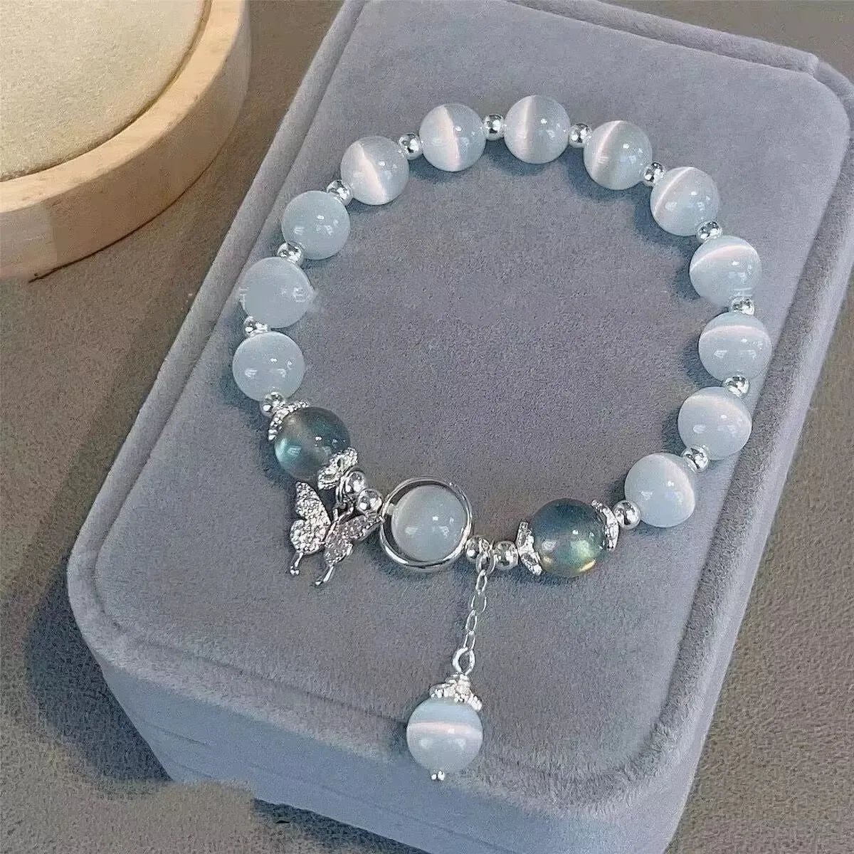 Women's glass butterfly drop-shape bracelet in a grey colourway with round details.