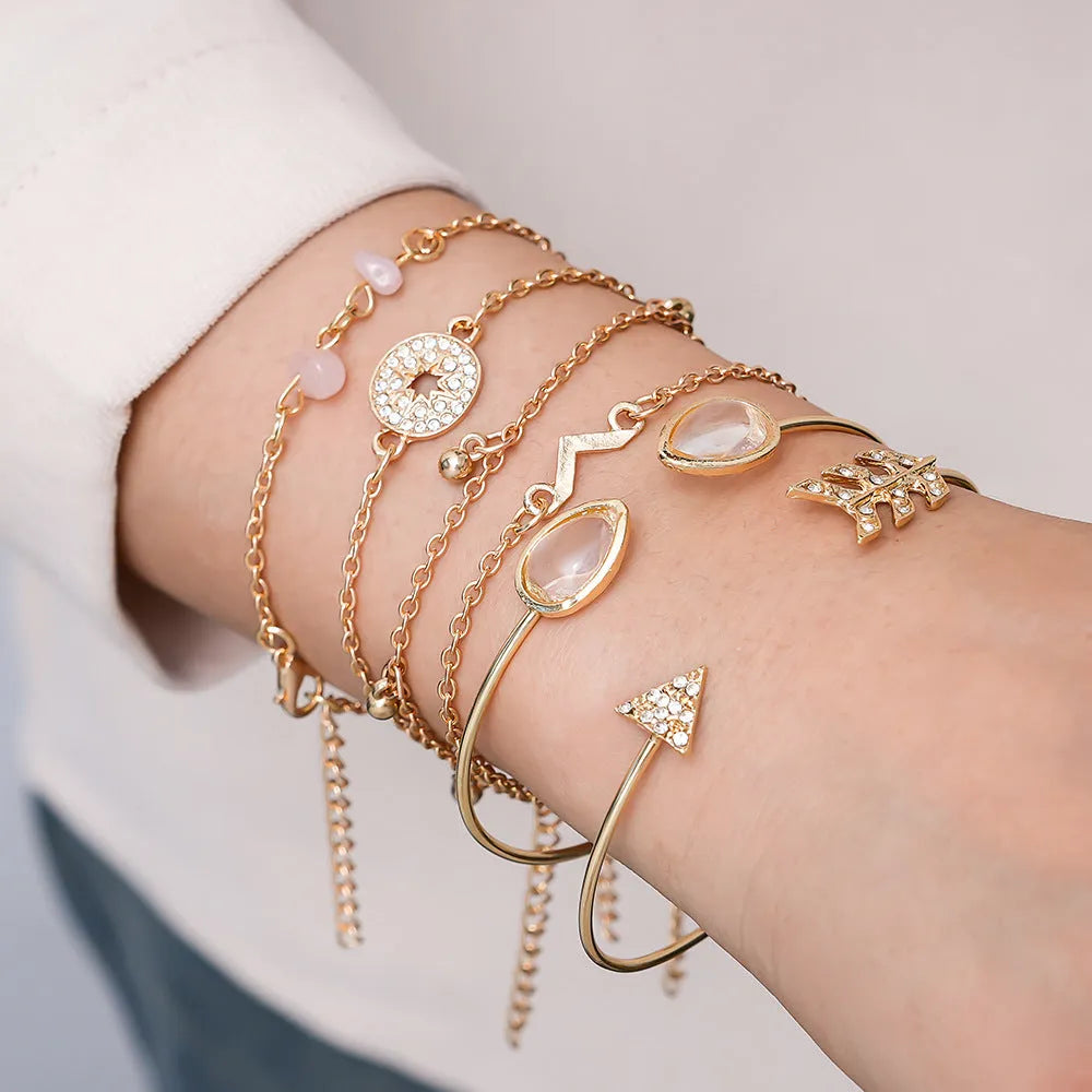Gold-coloured zinc alloy bracelet set with arrow, water droplet, and V-shaped charms