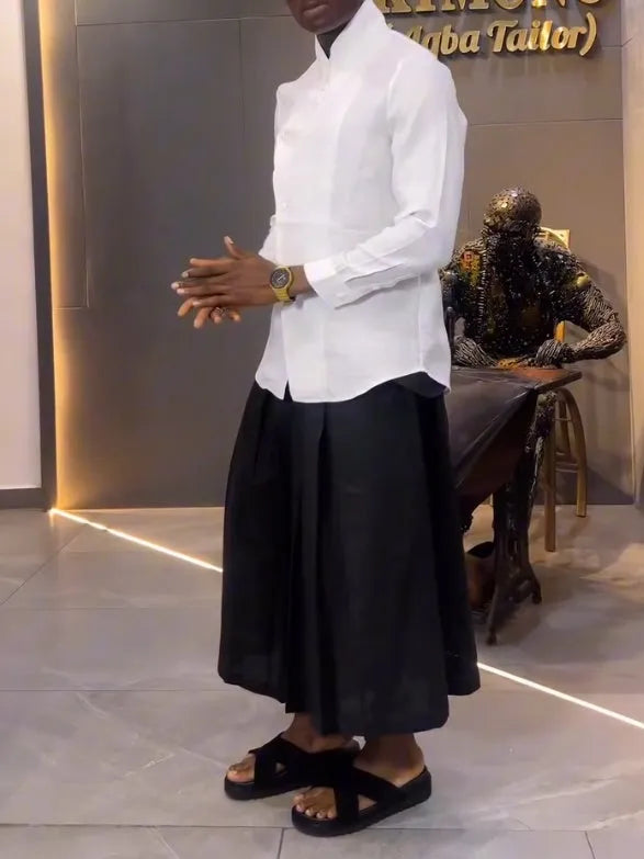 Women's white asymmetrical long sleeve shirt and black pleated trousers casual co-ordinates set on a hanger.