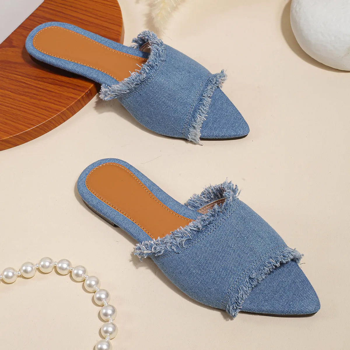 Women's denim flat slippers with a tassel, shown in available colours like apricot, black, and wine red.