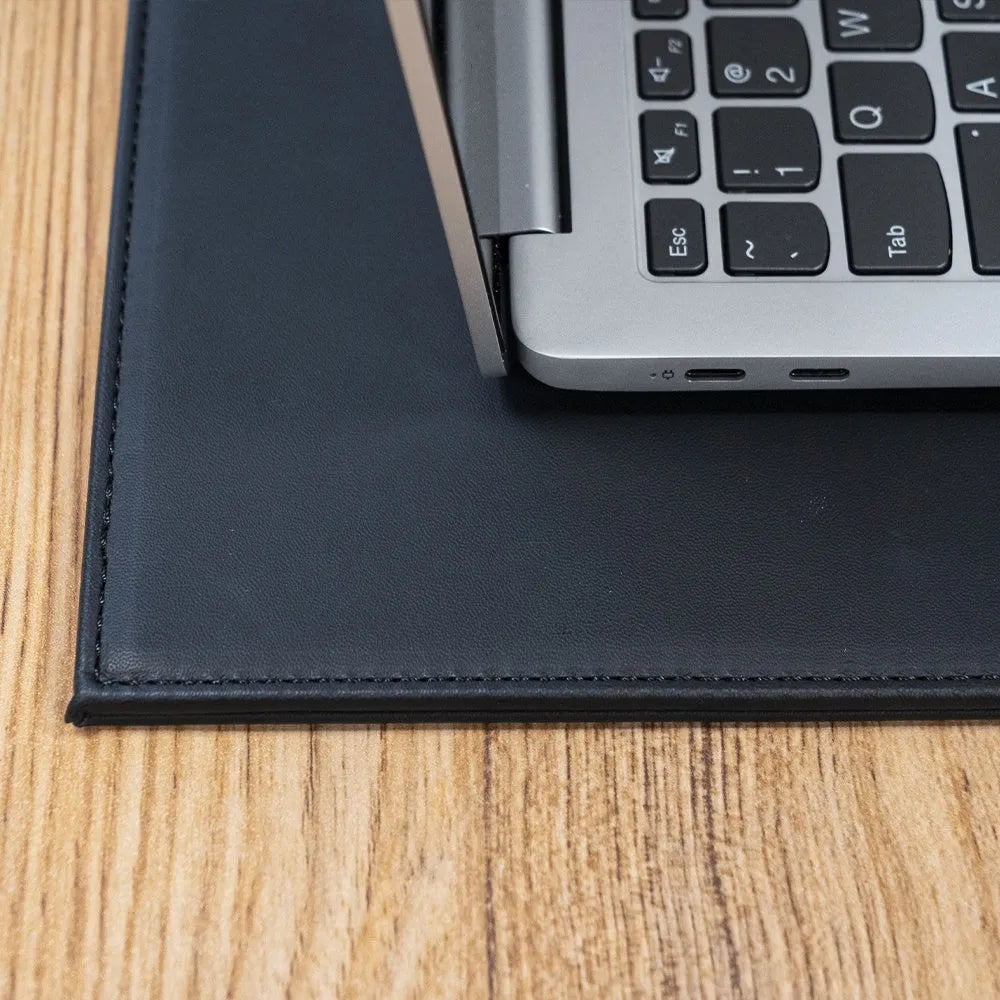 Heat-insulating laptop pad in black, gold, blue, and green colours on a desk