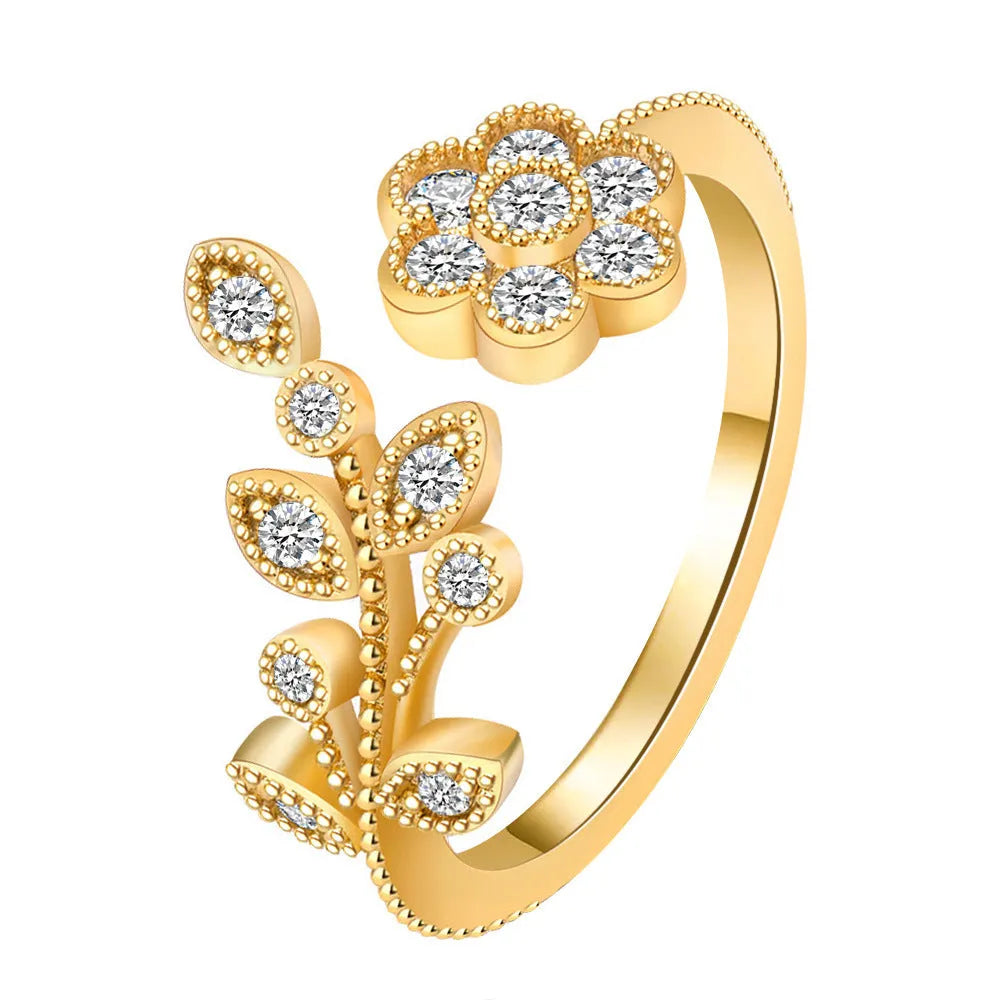 Women's open ring made of copper with a diamond finish, shaped as a detailed flower with leaves, shown in gold and white colour options.