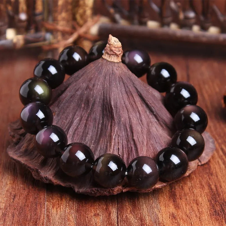 Natural icy obsidian crystal Pi Xiu bracelet with geometric beads on a white background.