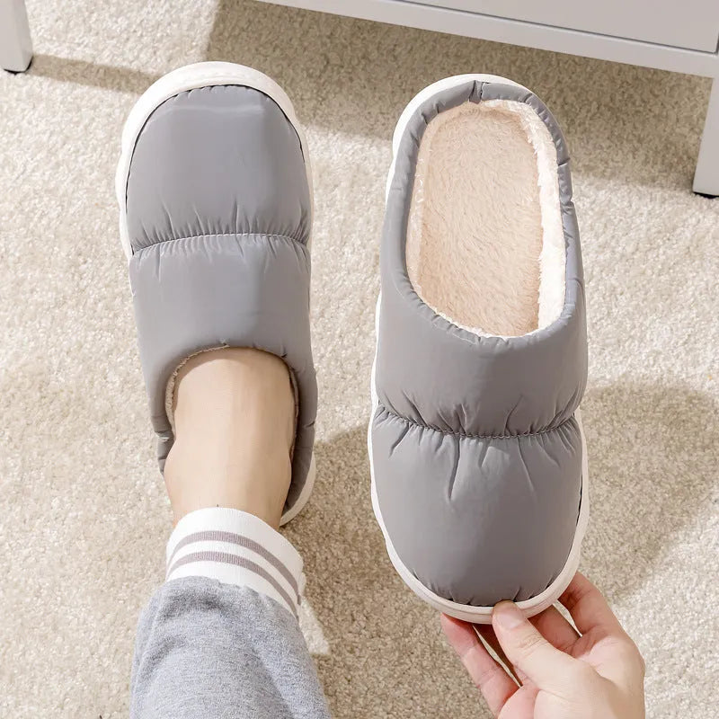 Pair of down cotton indoor slippers with artificial leather upper and thick rubber sole.