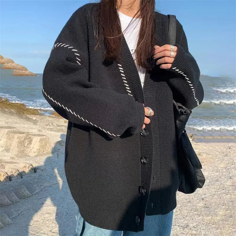 Women's loose fit black knitted cardigan coat with long sleeves.