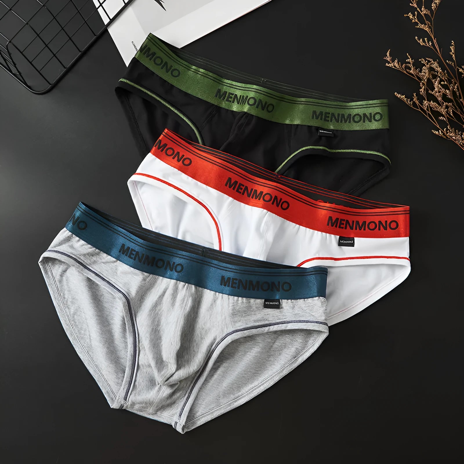 Men's low waist cotton briefs in a selection of solid colours including black and blue, white and red.