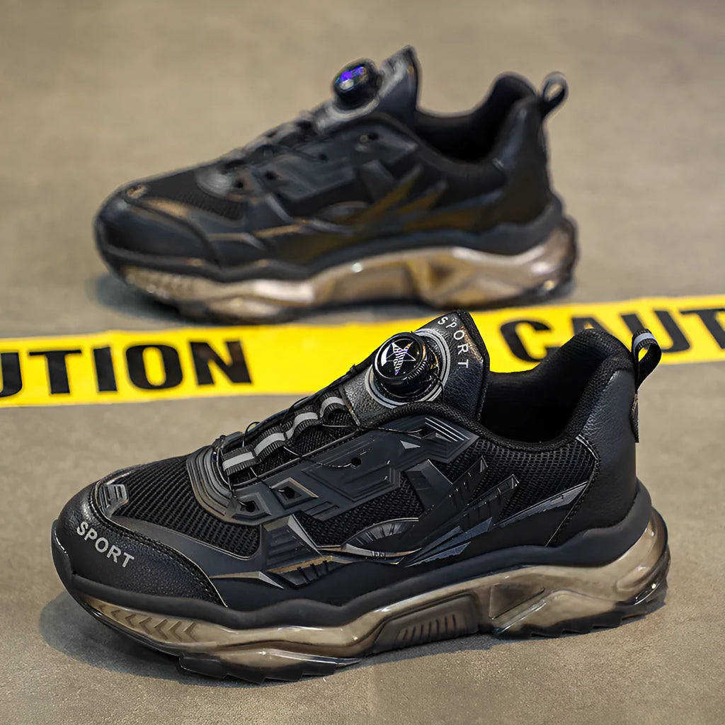 Men's black casual shoes with a rotating button closure and mesh upper on a rubber sole.